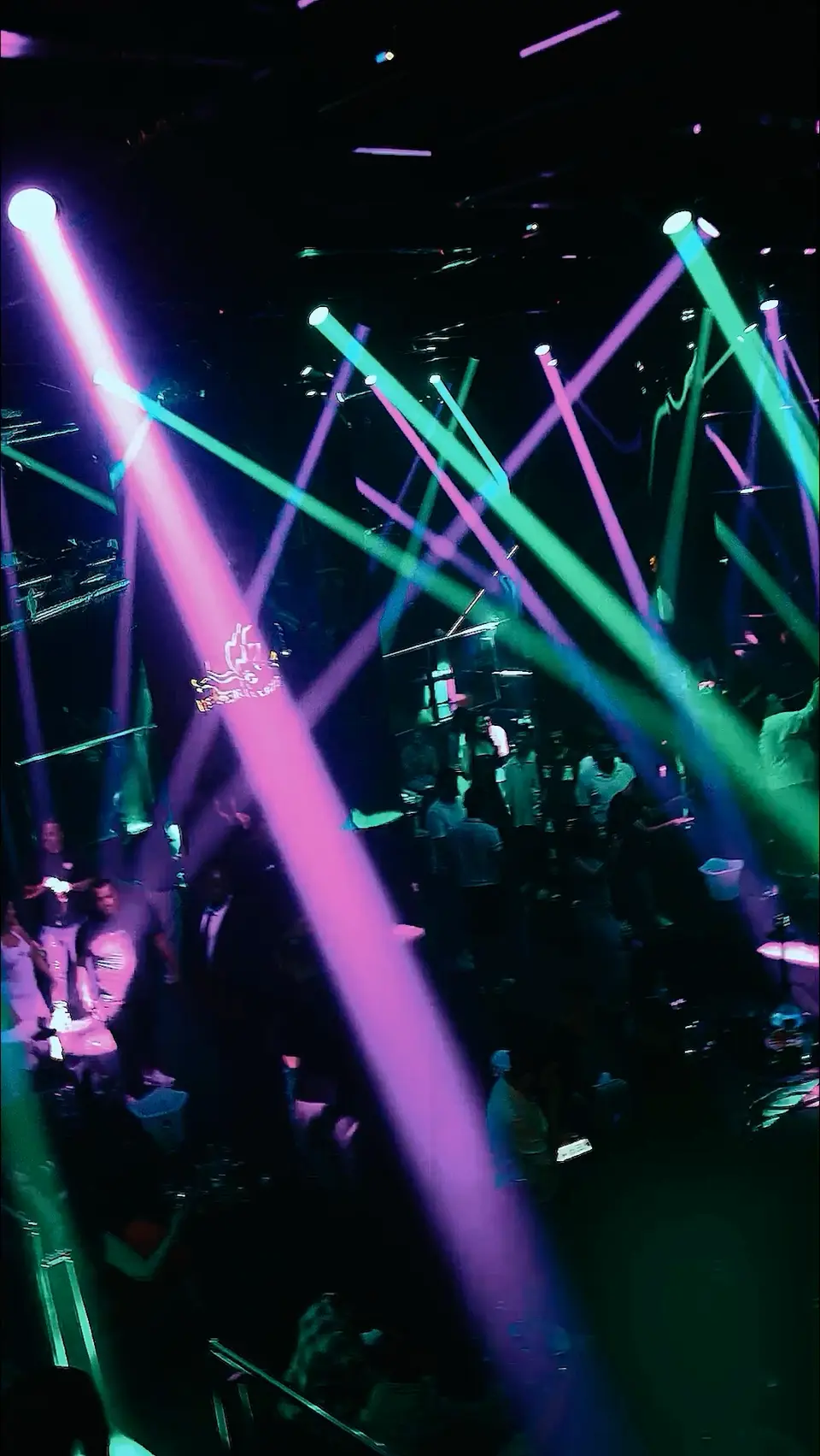 Purple and green beam lighting across the main room